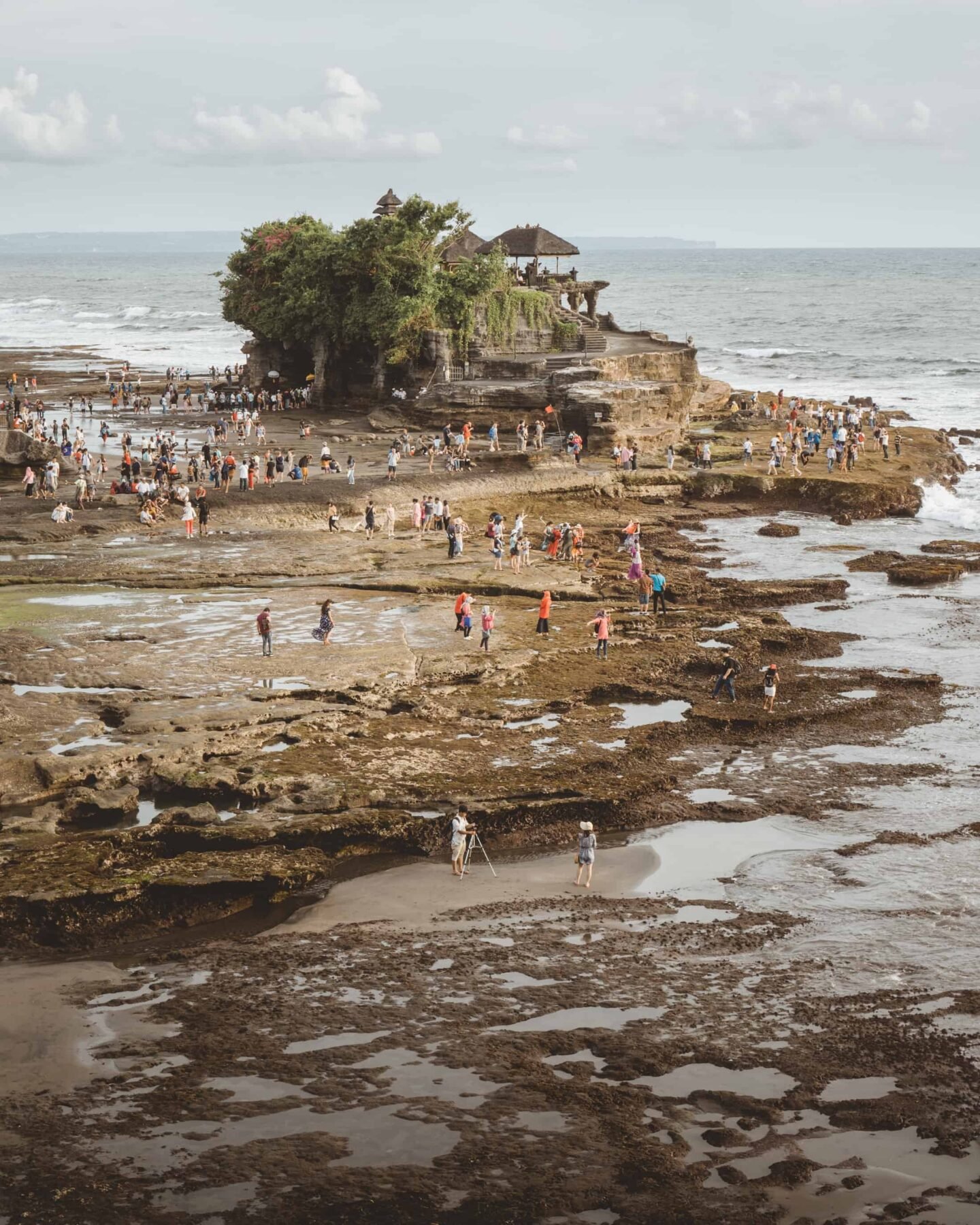 Have you ever wondered whether you should visit Tanah Lot Temple? It is one of the top attractions in Bali Indonesia and one of the most stunning sunsets in all of Asia! The temple is a top bucket list attraction to add to your list of things to do in Bali- and a perfect thing for all travellers- here's why! #bali #tanahlot #thingstodo